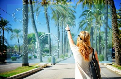 Woman on the street points to a holographic screen